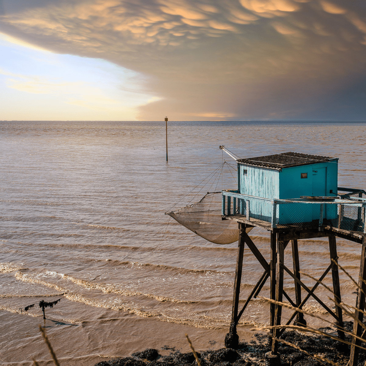 Carrelet sur l'océan en Charente-Maritime au coucher du soleil, illustrant les techniques de nettoyage professionnelles d’Hydrios Wave, expert en hygiène et propreté.