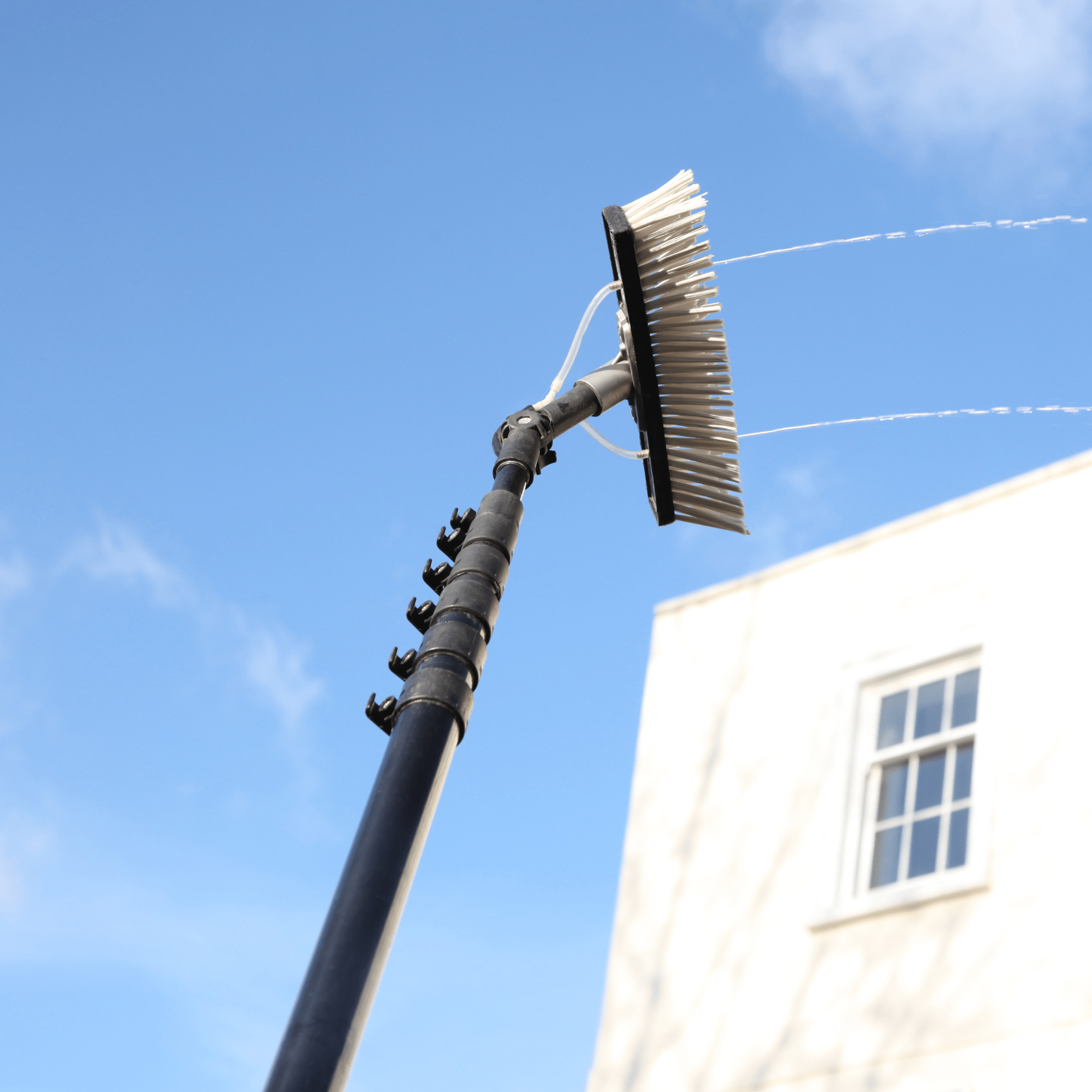 Nettoyage de vitres en hauteur avec perche télescopique à eau pure par Hydrios Wave en Charente-Maritime, sur façade extérieure.