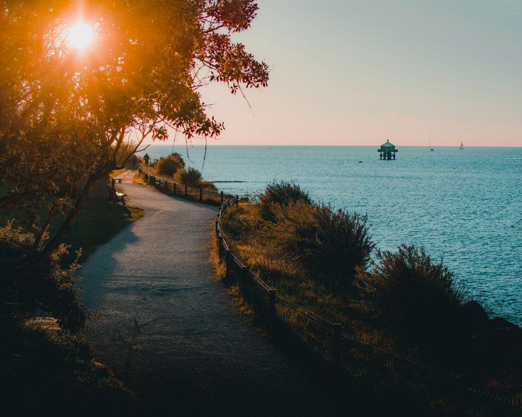 Promenade du Mail à La Rochelle au coucher du soleil, vue sur le phare du Bout-du-Monde.